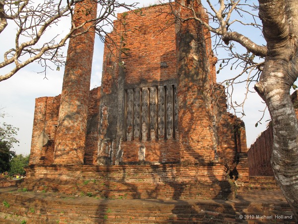 Rear wall of the prayer hall, framed by frangipani trees