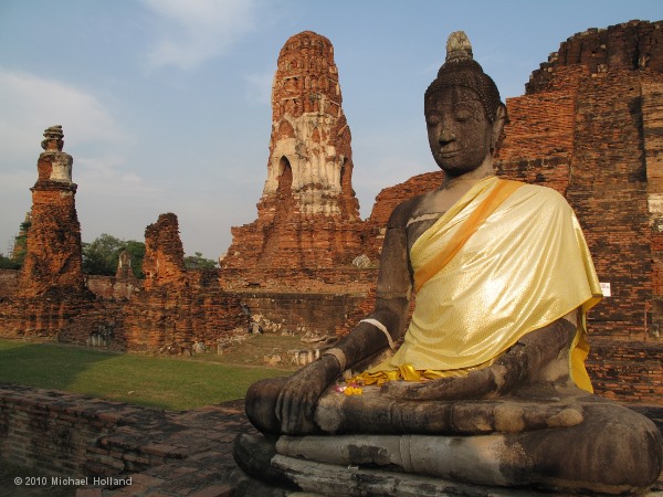 Seated Buddha image with central sanctuary in the background