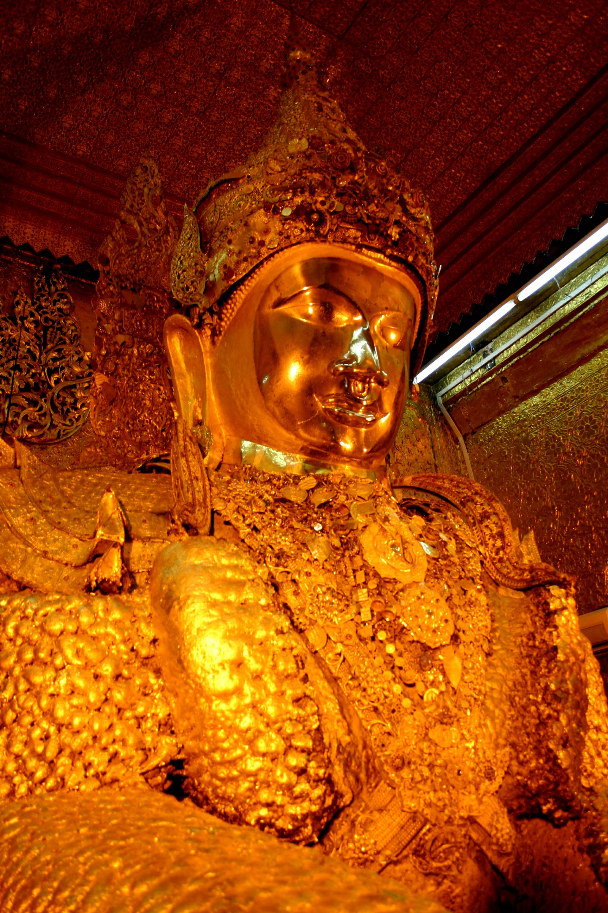 The gilt face of the Maha Muni Buddha image