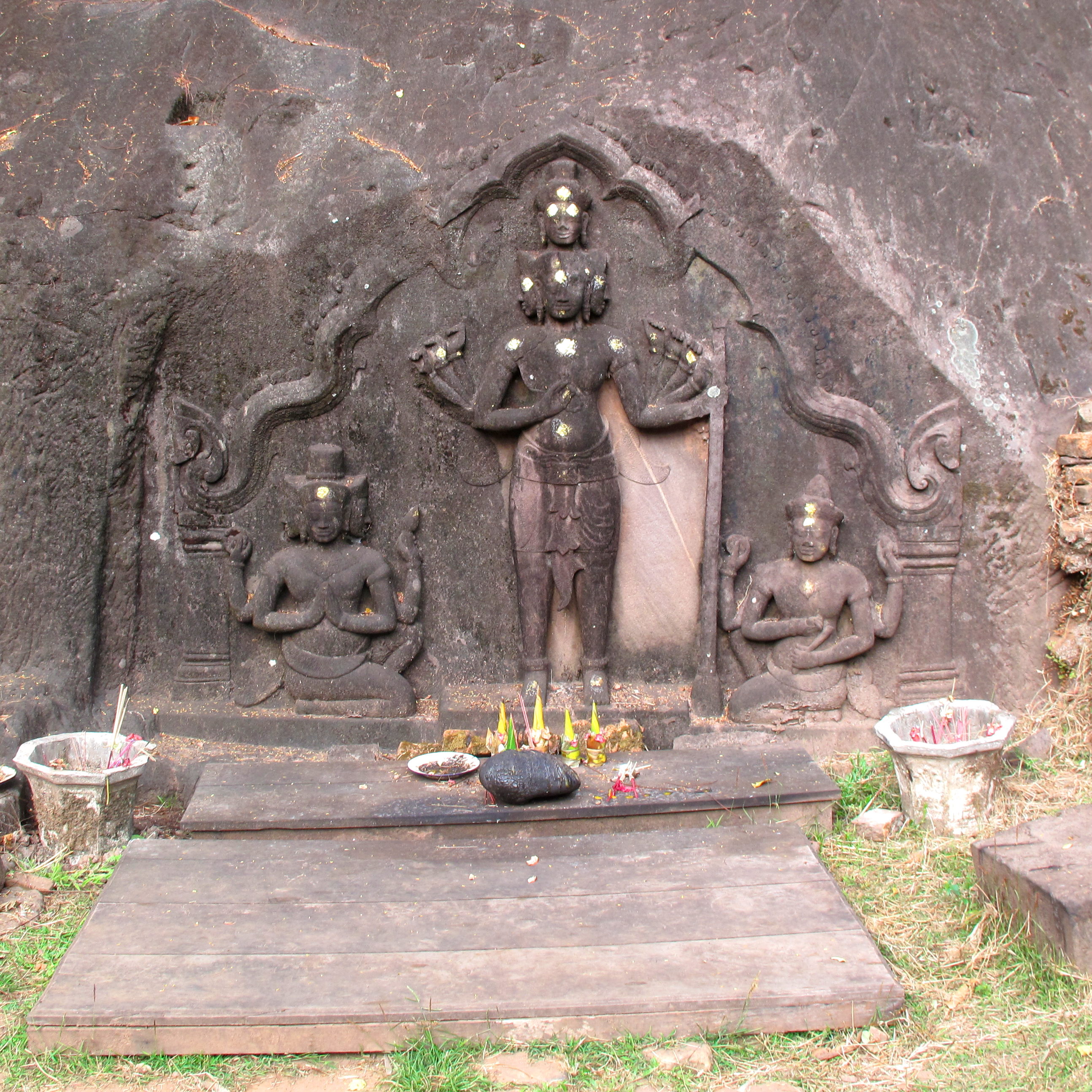 Brahma and two supplicants carved into the cliff wall